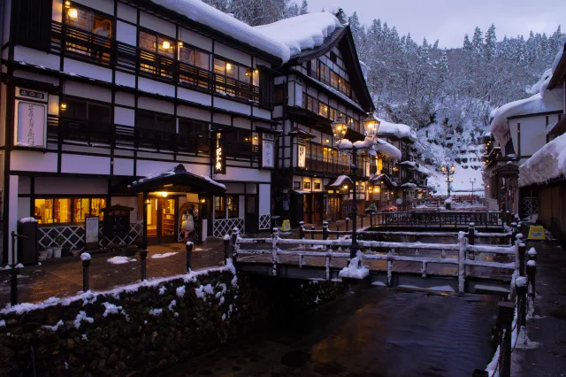 積雪覆蓋的銀山溫泉木造旅館街,河岸建築與雪景形成冬季代表畫面